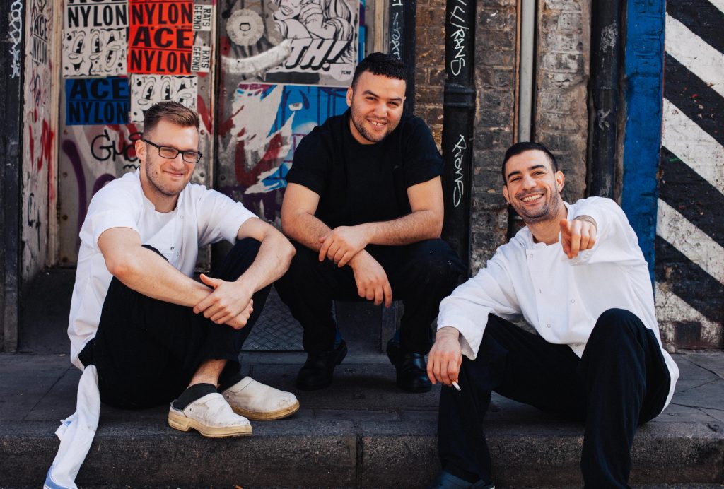 drie jongens zitten op de stoep